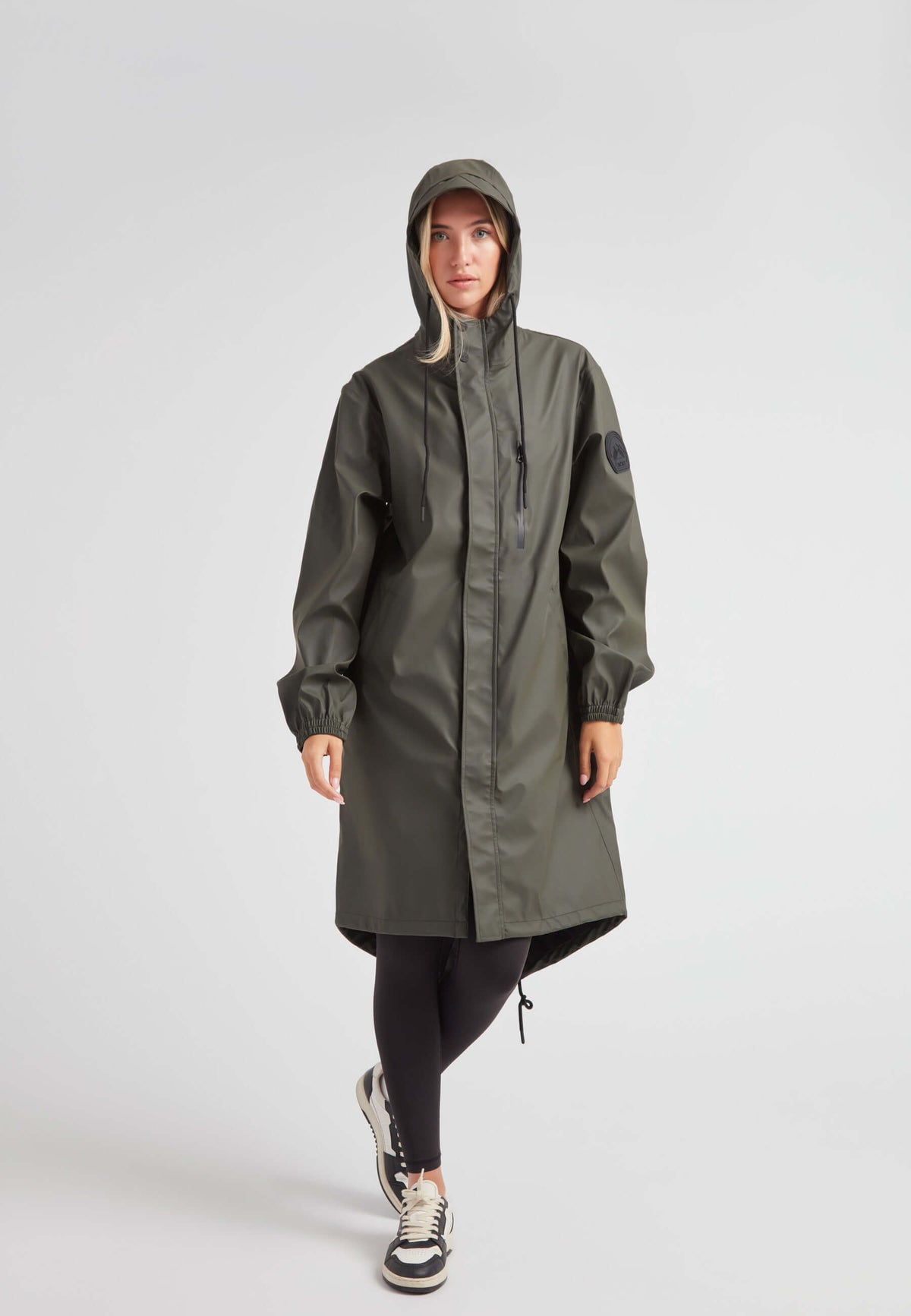 Elements unisex raincoat in khaki worn by a model, showcasing a lightweight, practical design with a hood.