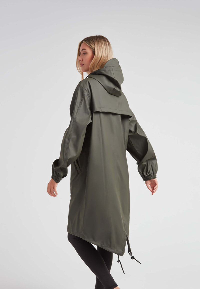 Woman wearing ELEMENTS unisex raincoat in khaki, showcasing its lightweight design and practicality.