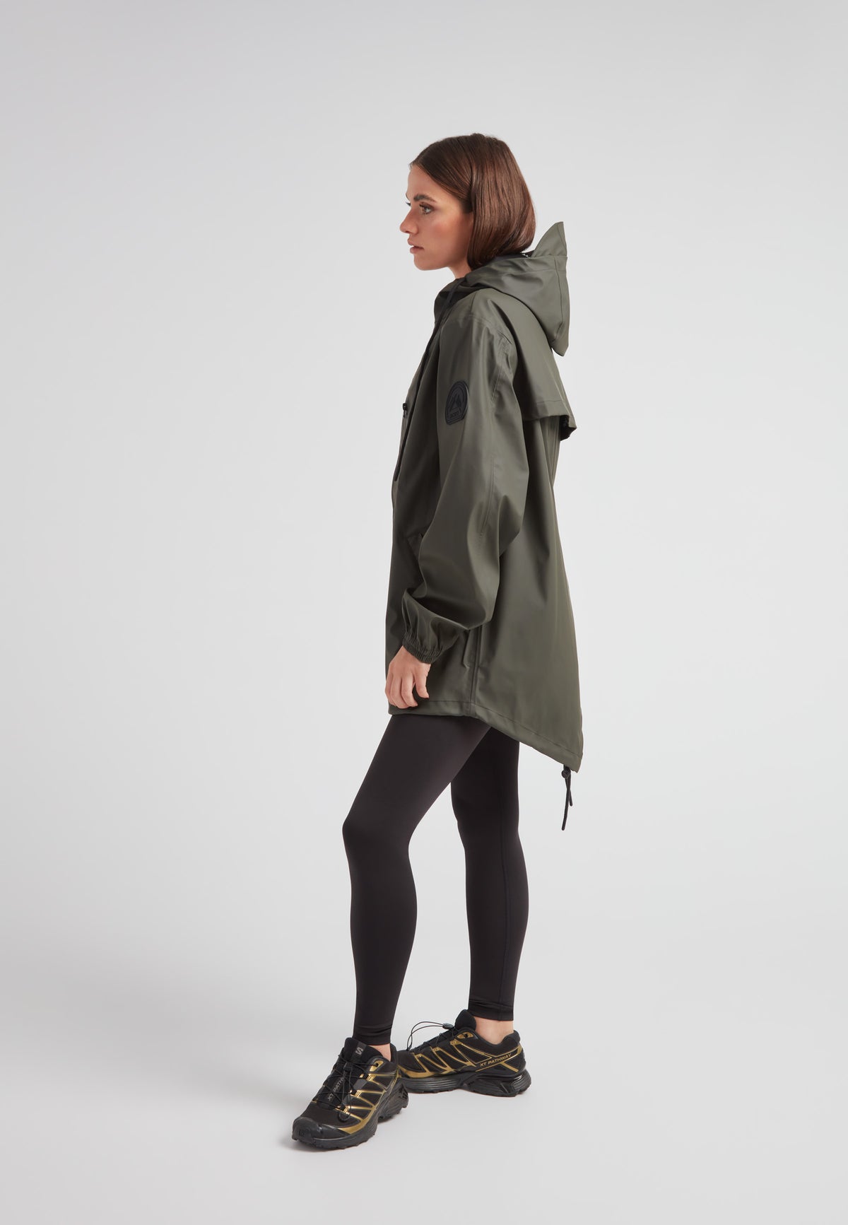 Model wearing ELEMENTS Raincoat 2.0 Khaki with black leggings and shoes, showcasing its lightweight design and versatility.