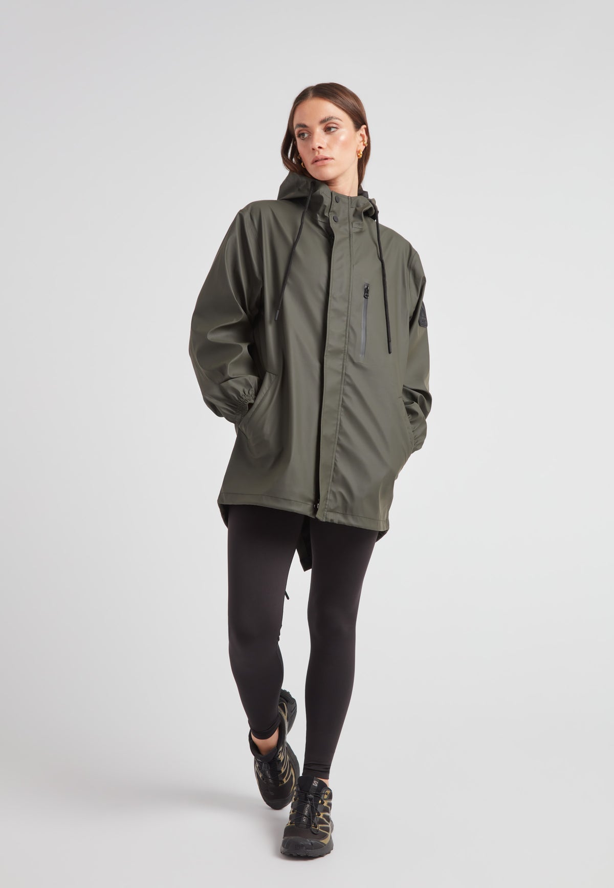 Female model wearing ELEMENTS Raincoat 2.0 Khaki, showcasing its lightweight and versatile design.