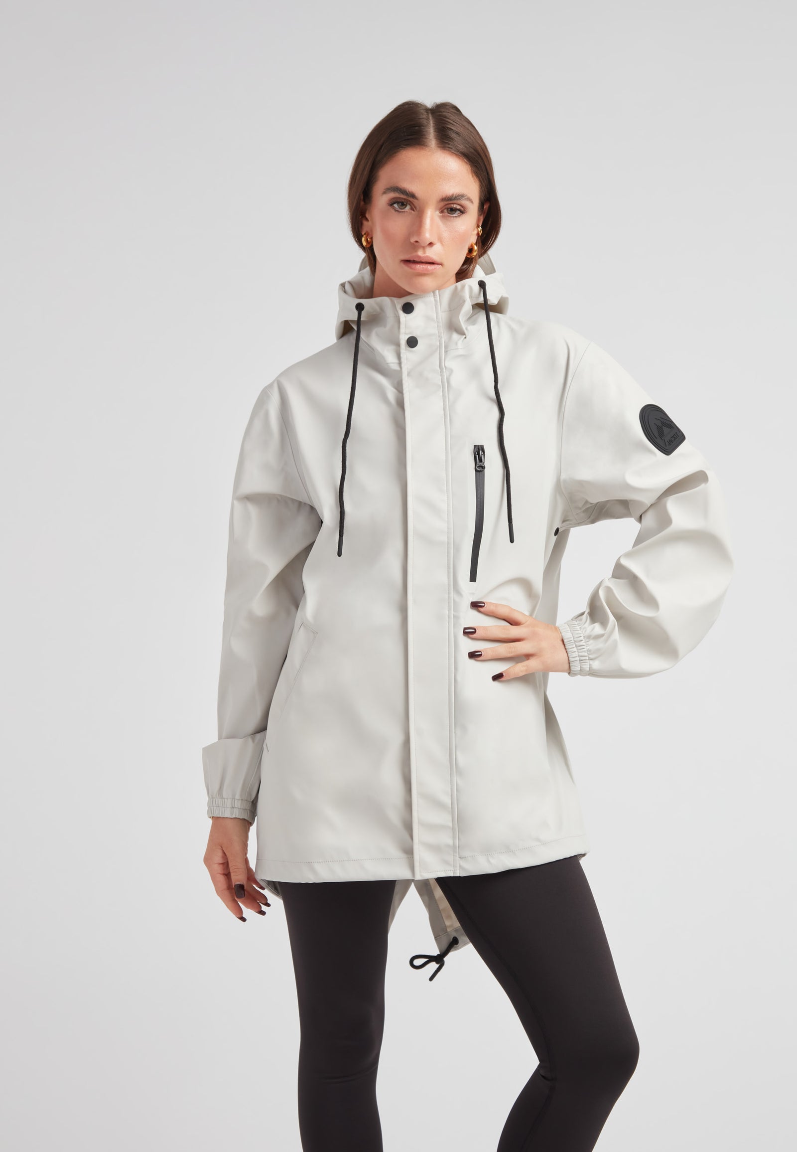 Model wearing the ELEMENTS Raincoat 2.0 Stone, showcasing its lightweight weather protection design.