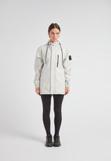 Woman wearing the ELEMENTS Raincoat 2.0 Stone, designed for lightweight weather protection and comfort.