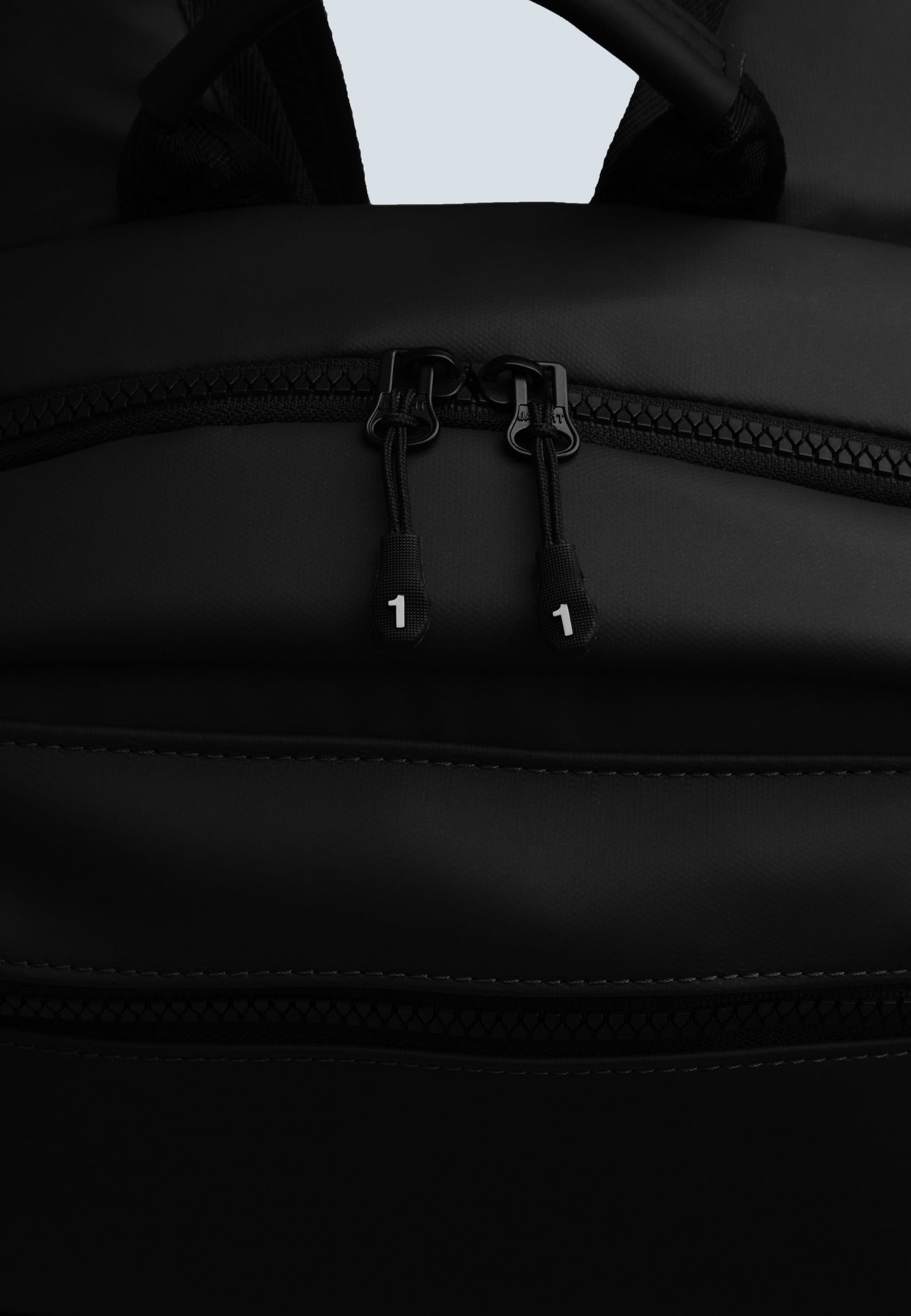 Close-up of JACK1T's black water resistant backpack zipper detail and fabric.