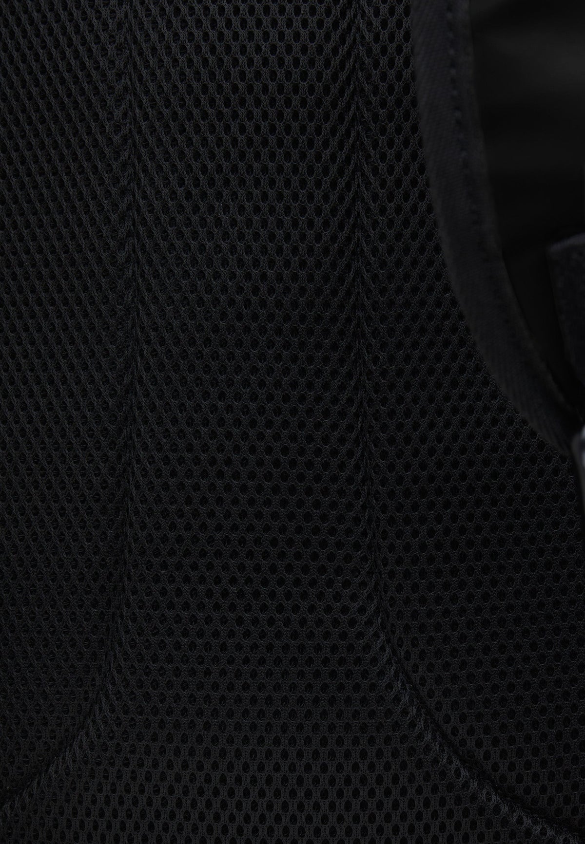 Close-up view of the breathable mesh material on JACK1T's black water resistant backpack.