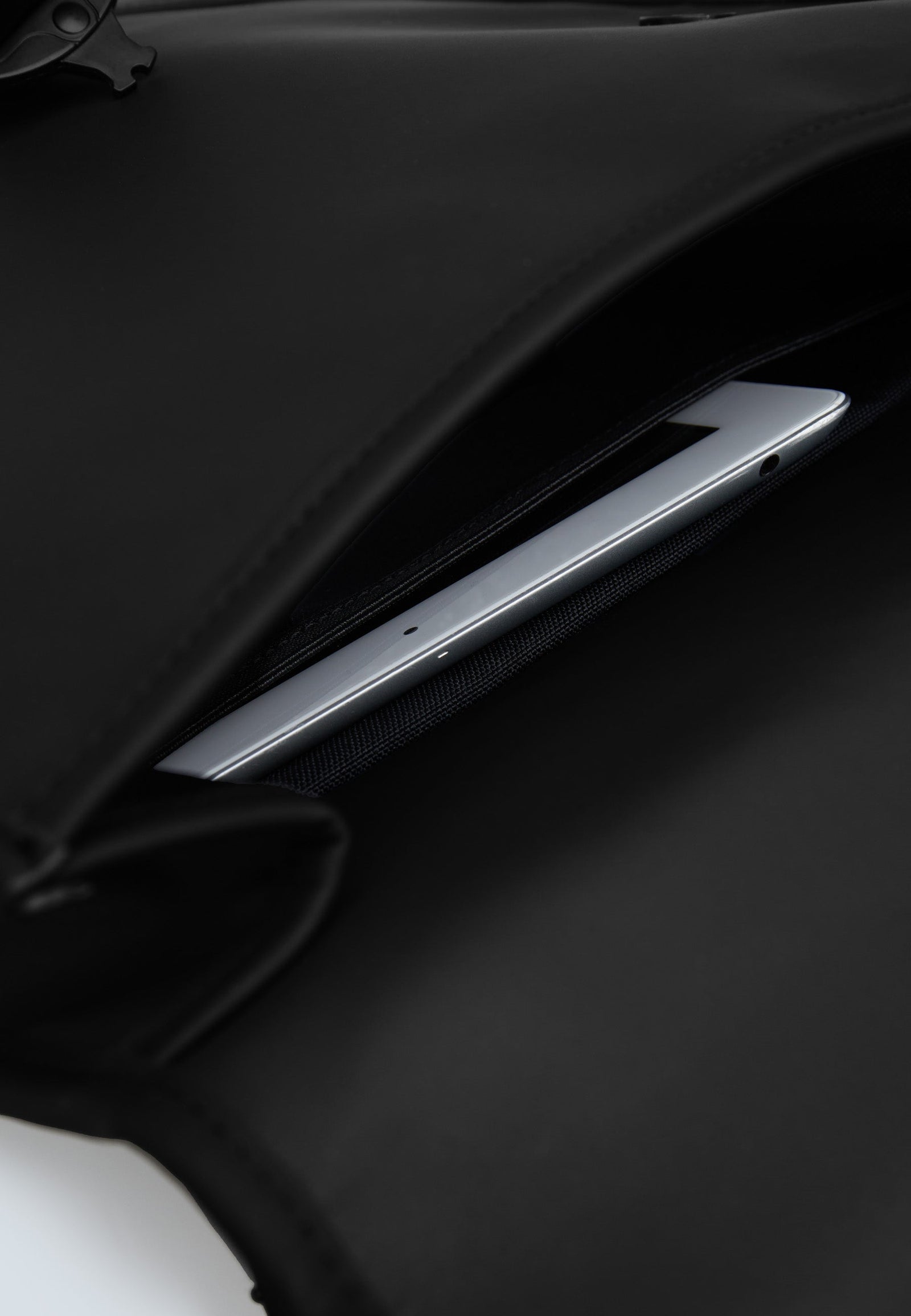 The JACK1T slim messenger laptop bag in black with a laptop securely stored in its compartment.