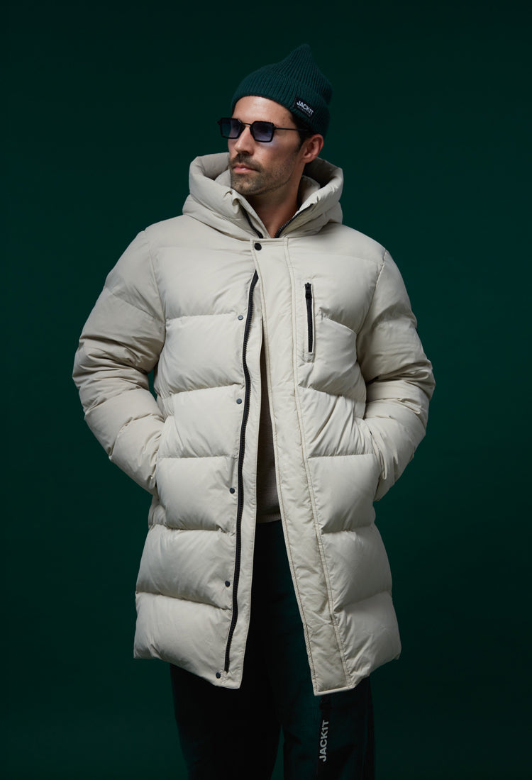 A model wearing a cream-colored JACK1T puffer coat, styled with sunglasses and a beanie.
