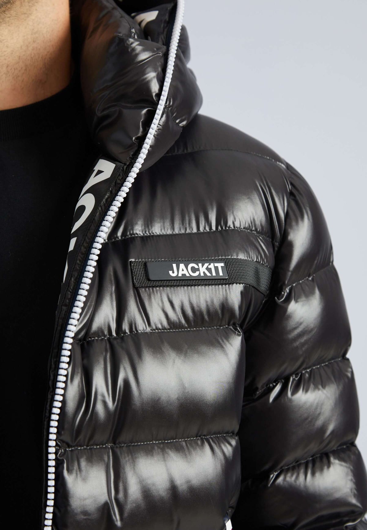 Close-up of R3D Tricolore Black puffer jacket with shiny finish and zip closure details.