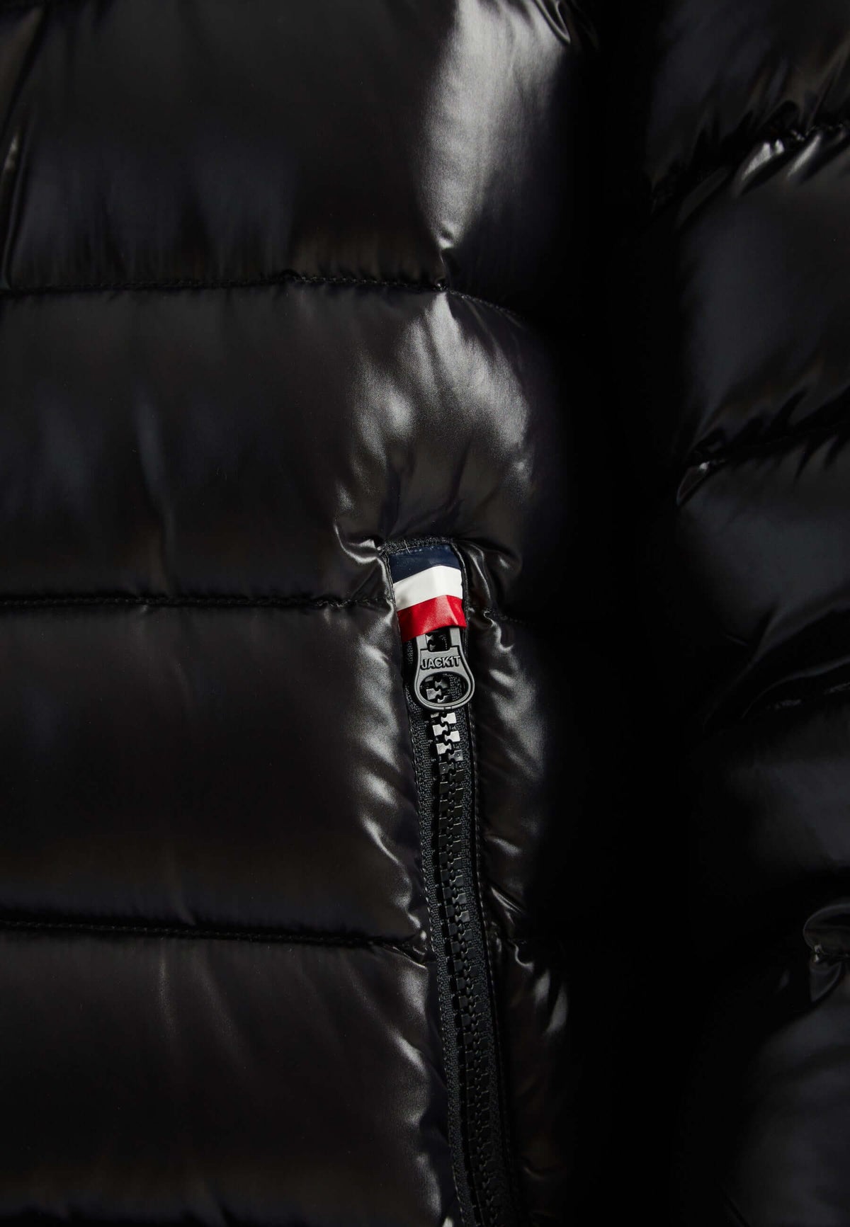 Close-up of zipper detail on a lightweight black puffer jacket.