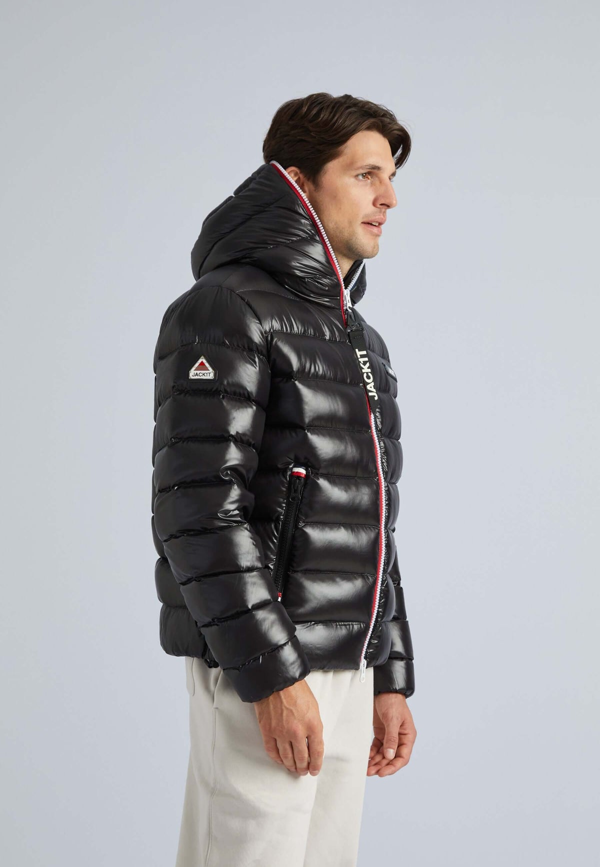 Man wearing a R3D Tricolore Zip Jacket Black, lightweight black puffer jacket with hood, stylish and functional.