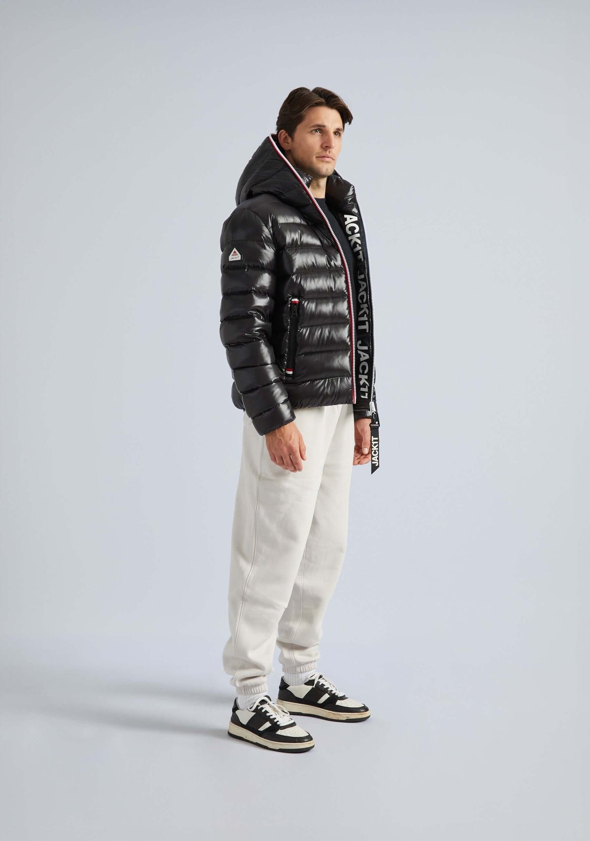 Model wearing a stylish Black puffer jacket from R3D collection, paired with white sweatpants.