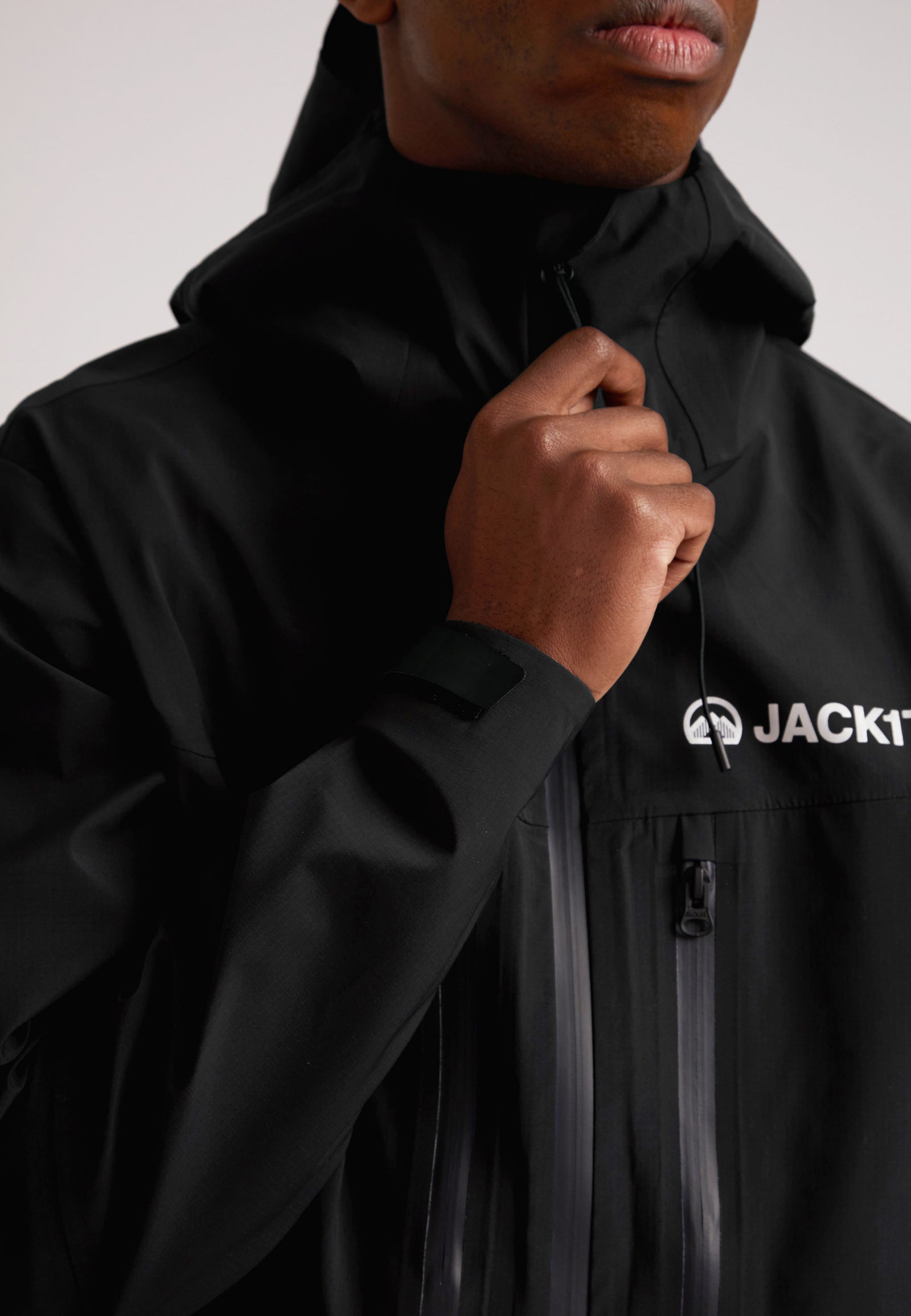 Black mens Lithium waterproof jacket with hood and zip fastening for outdoor protection against the elements.