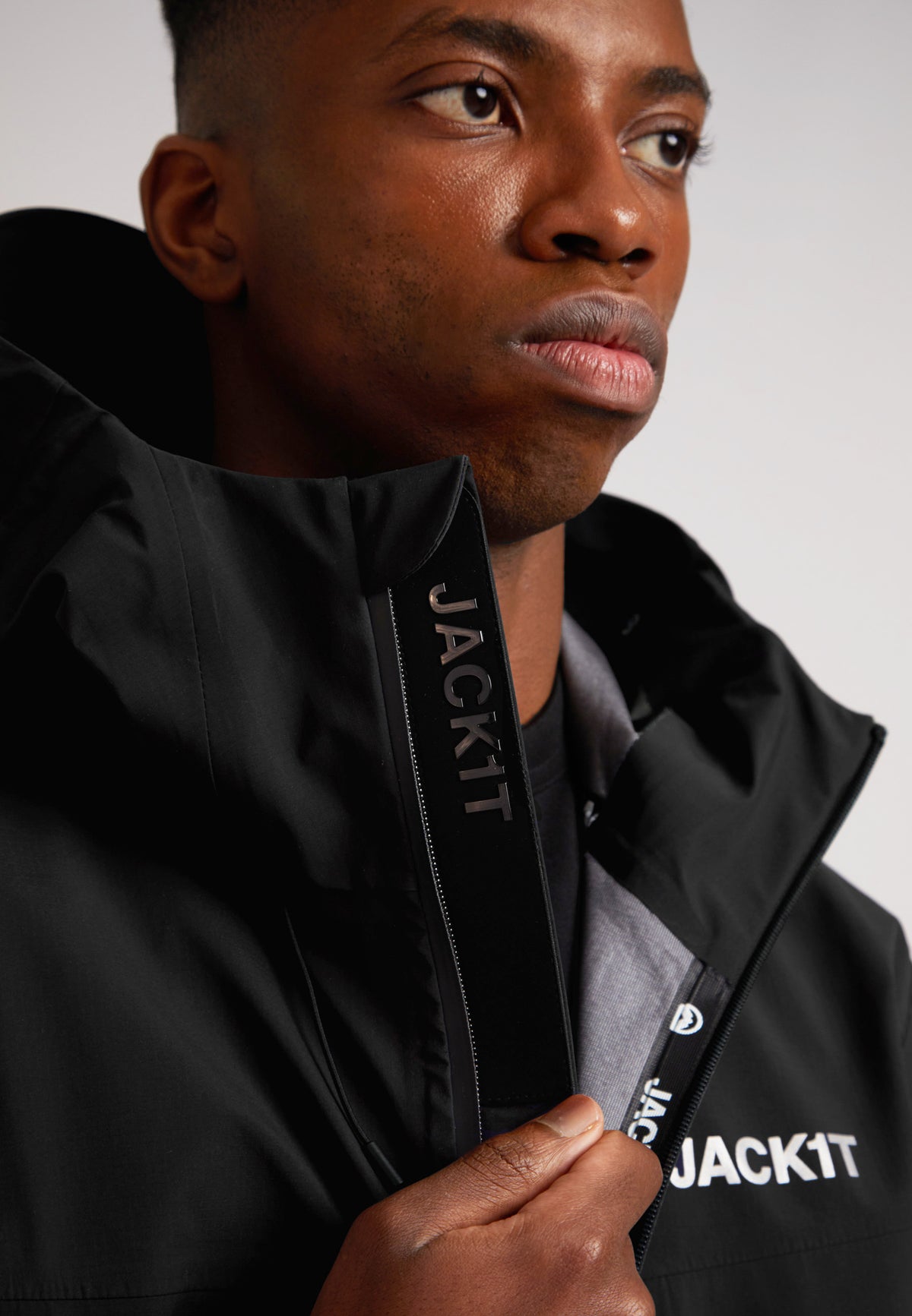 Black mens Lithium waterproof jacket worn by a model, showcasing its sleek design and waterproof features.