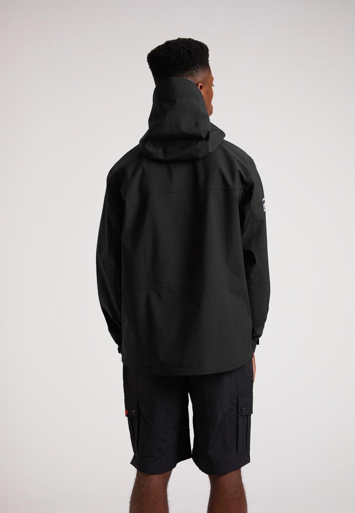 Black mens Lithium waterproof jacket viewed from the back, showcasing the hood and sleek design.