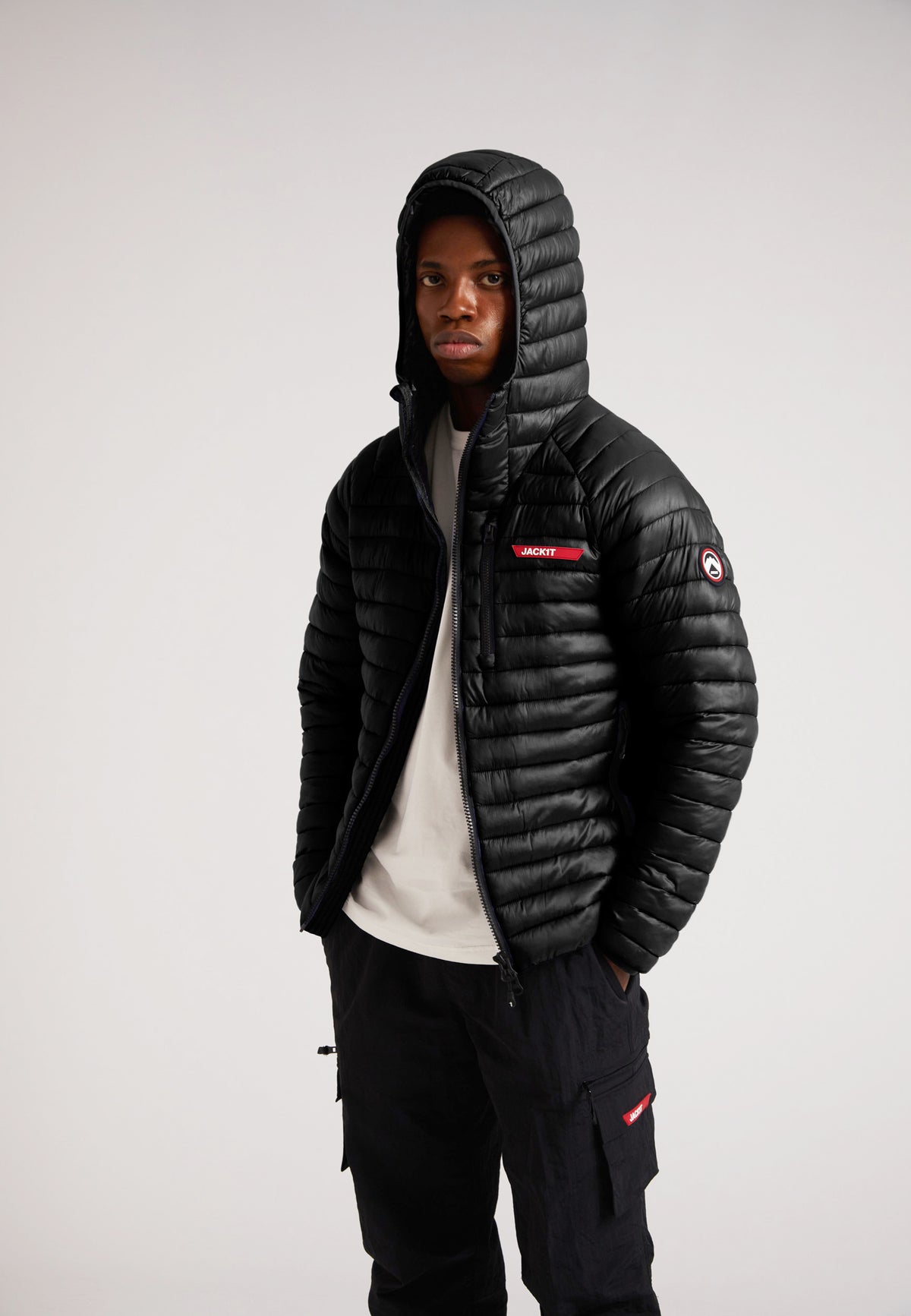 Model wearing SATEL1TE Hooded Jacket 2.0 Black with a hood, showcasing its stylish and versatile design.