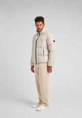 Cloud Lightweight Puffer Racer Jacket Stone worn by a man, featuring a funnel neck and box quilting in a stylish outfit.