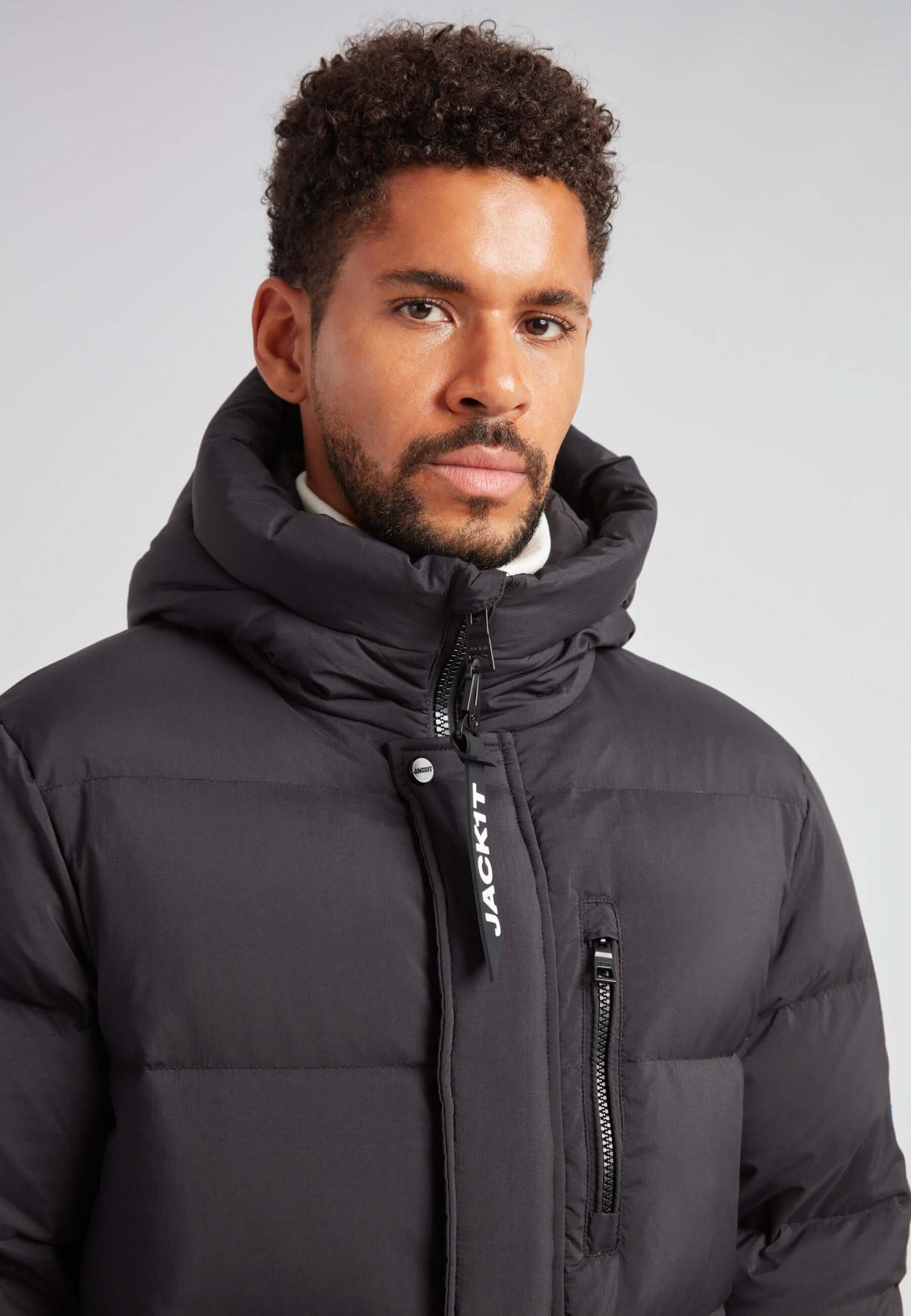 Model wearing a Mens Down Parka Coat Black, showcasing the adjustable hood and durable construction.