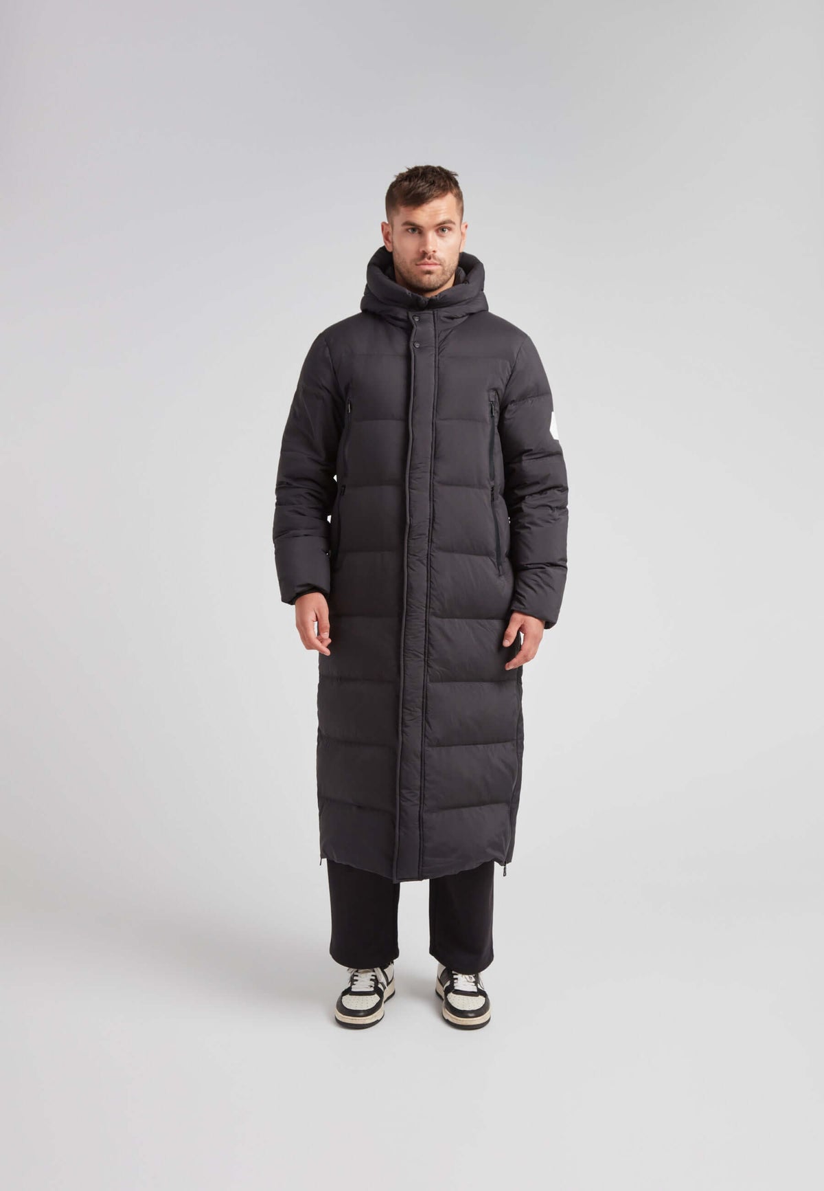 Mens Extra Long Puffer Coat in Black worn by a model, showcasing a sleek and warm winter design.