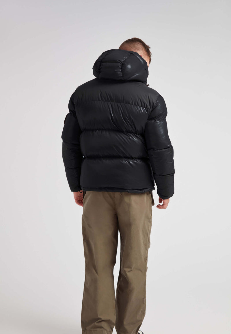 Back view of a man wearing an Expedition Parka Puffer Men Black jacket, showcasing its stylish, oversized hood and puffer design.
