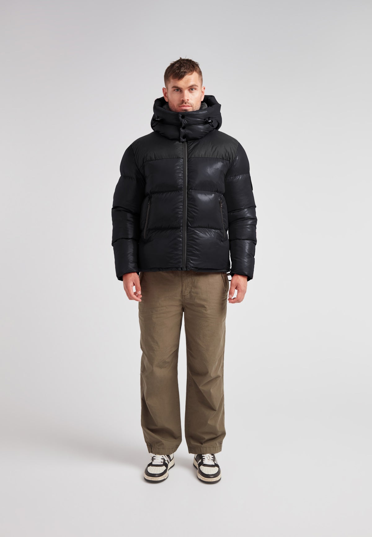Man wearing the Expedition Parka Puffer Men Black jacket, featuring a boxy silhouette and oversized hood.