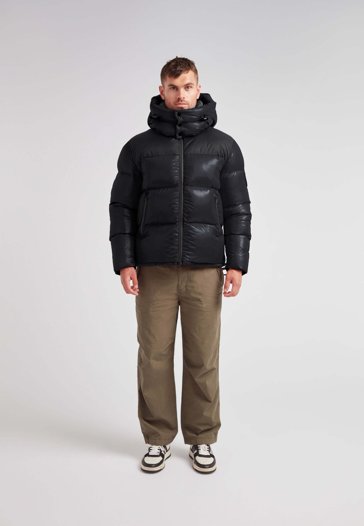 Man wearing the Expedition Parka Puffer Men Black jacket, featuring a boxy silhouette and oversized hood.