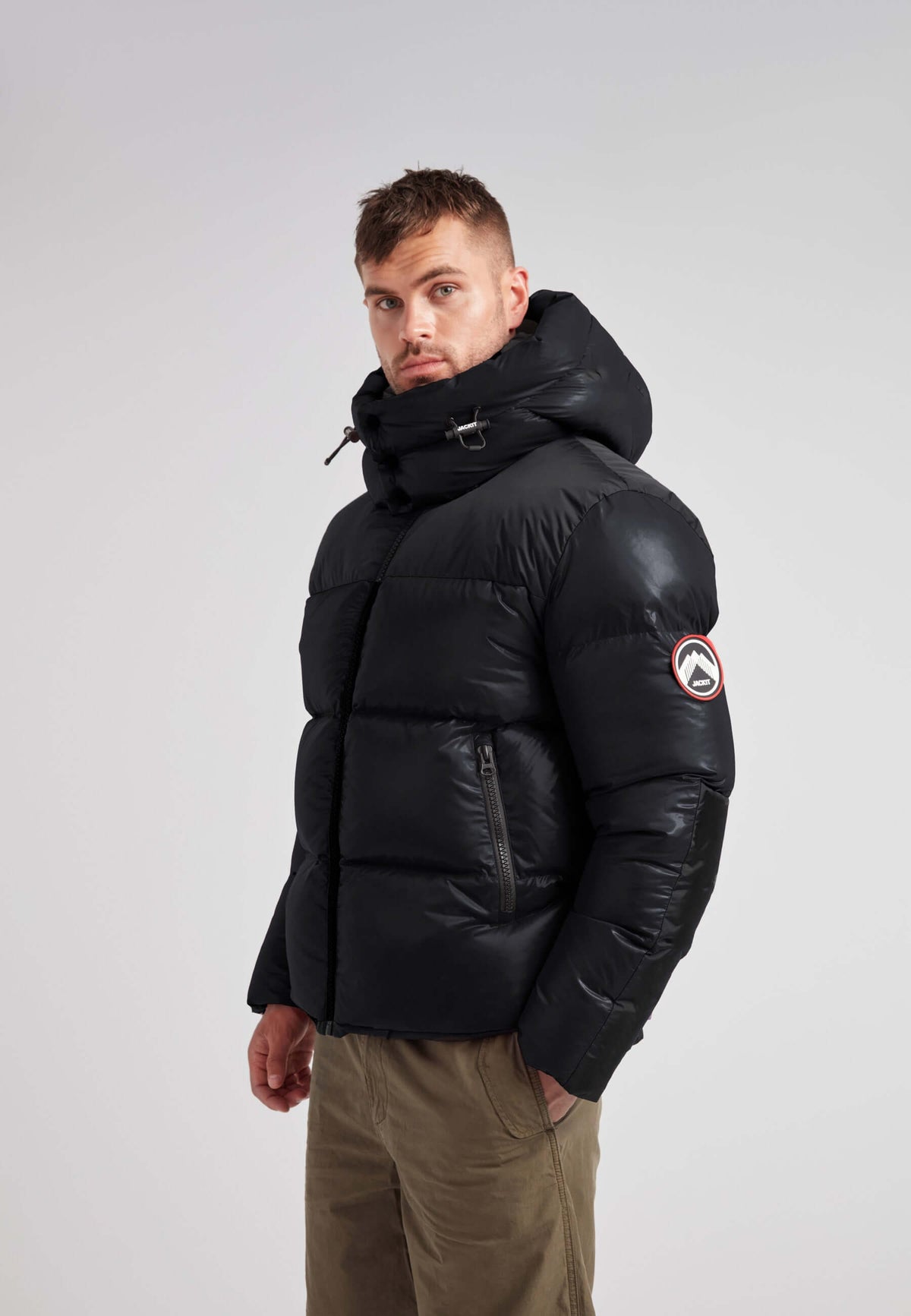 Man wearing Expedition Parka Puffer Men Black jacket with oversized hood and boxy silhouette.