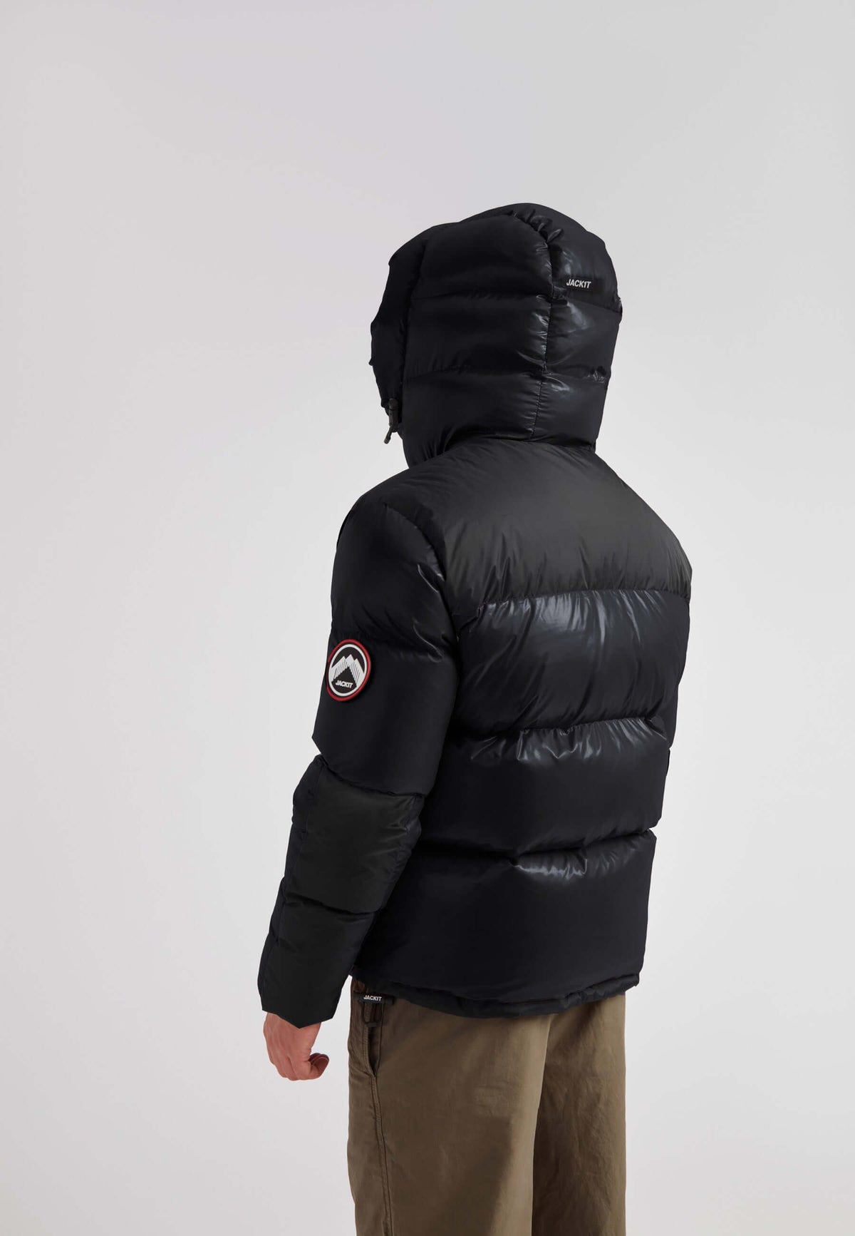 Back view of a man wearing the Expedition Parka Puffer Men Black jacket with oversized hood.