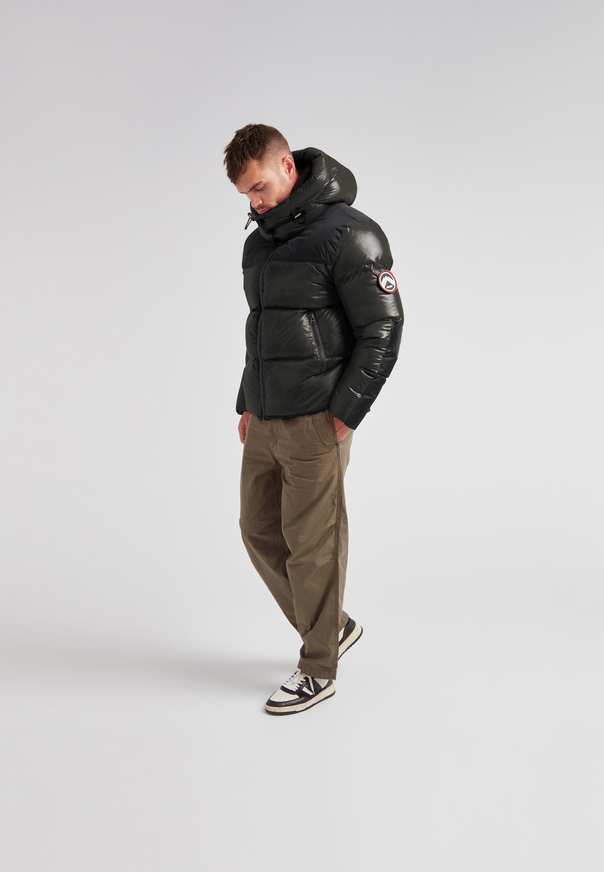 Man wearing Expedition Parka Puffer Men Emerald jacket with oversized hood and boxy silhouette.