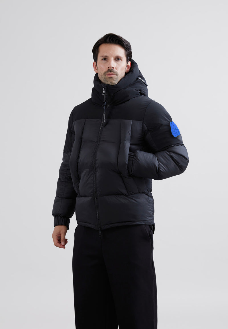 Luna Lightweight Mens Puffer Jacket Black shown on a model, featuring color panels and a hood, perfect for cold weather.