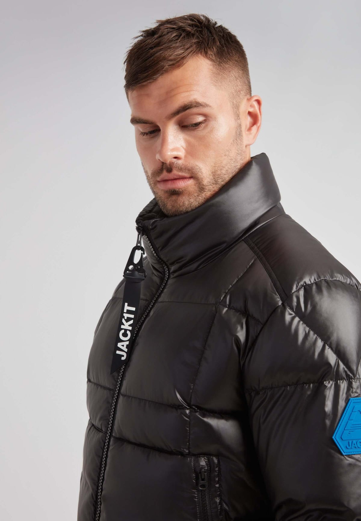 EZ Boxed Funnel Puffer Jacket Lux Black modeled by a man with a sleek design and a funnel neck for winter protection.