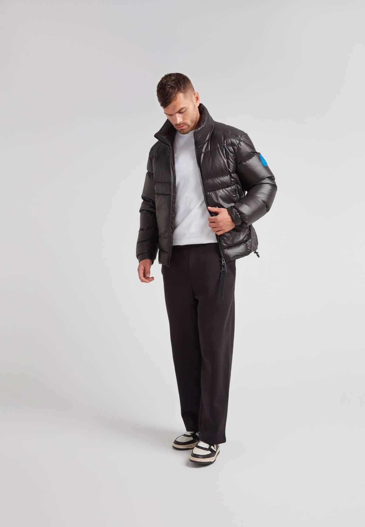 Man wearing EZ Boxed Funnel Puffer Jacket Lux Black with a casual outfit and stylish sneakers.