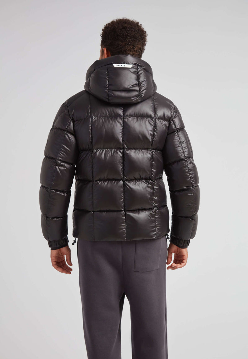 Back view of a man wearing the EZ Boxed Puffer Racer Jacket Lux Black, featuring a sleek quilted design and hood.