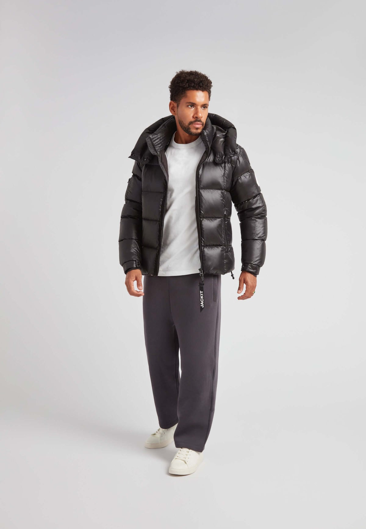 EZ Boxed Puffer Racer Jacket Lux Black worn by a man, showcasing its sleek urban design and warmth.