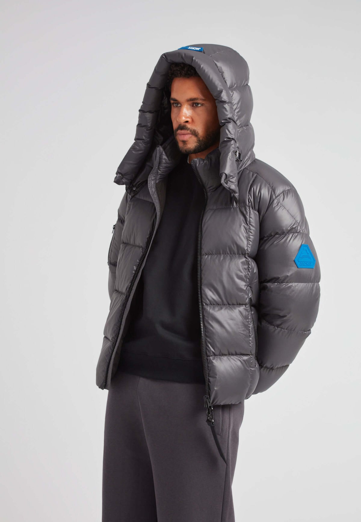 EZ Boxed Puffer Racer Jacket Lux Graphite worn by a man, featuring a hood and sleek design for winter protection.