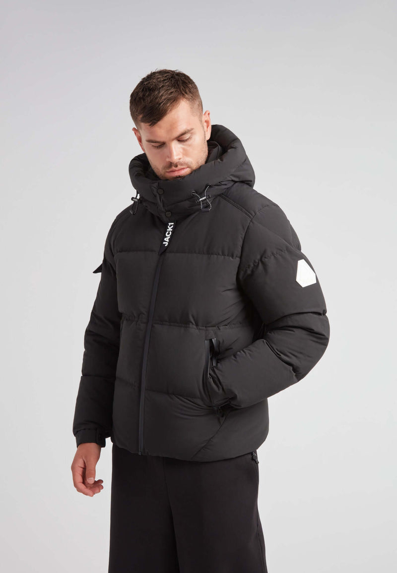 Man wearing the EZ Water Puffer Racer Jacket Matt Black, showcasing its winter style and features.