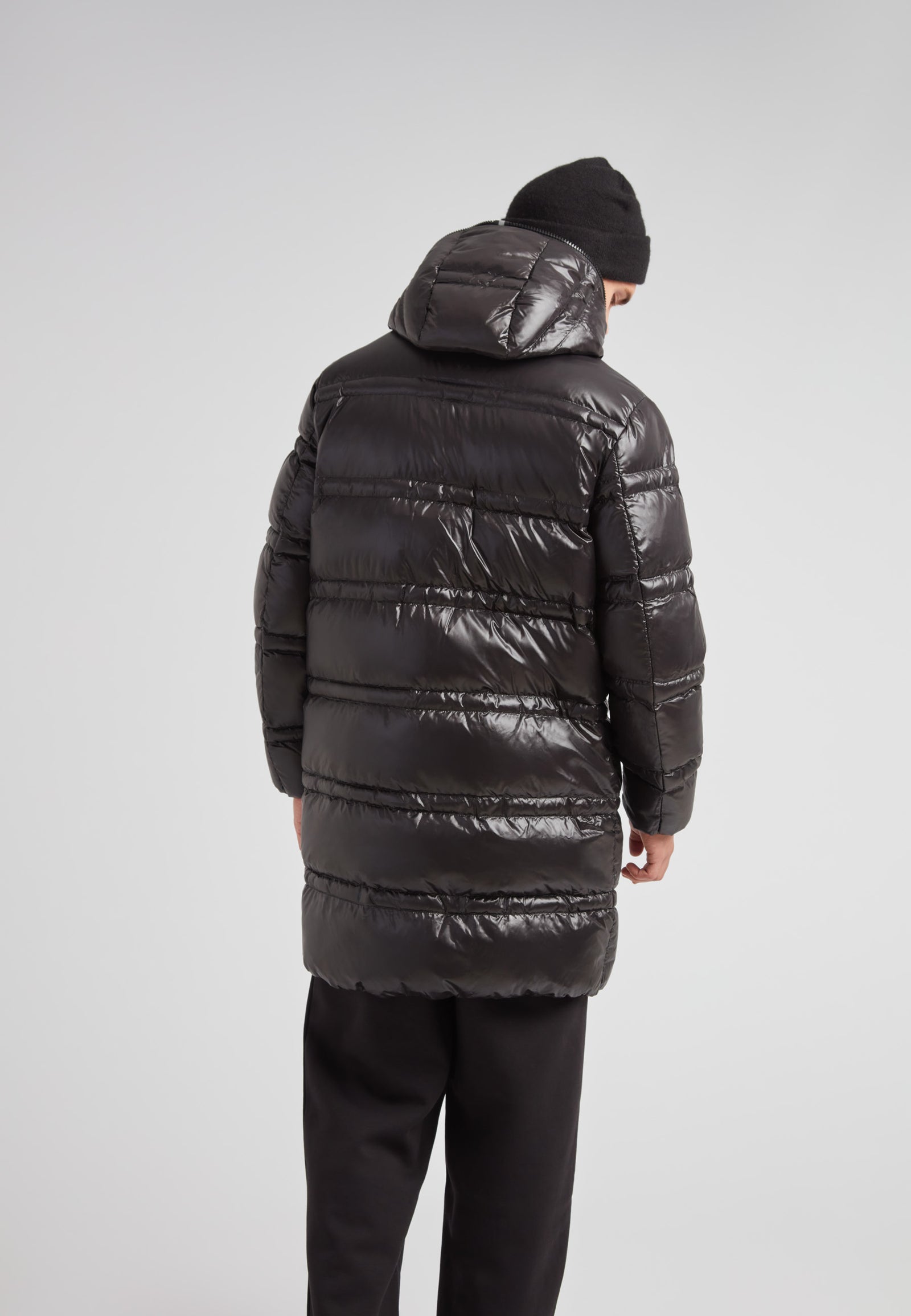 Back view of a man wearing the R4D Tramline Puffer Coat Lux Black, showcasing its sleek design and insulation features.