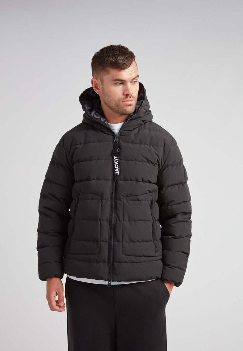 R4D Tramline Puffer Racer Jacket Matt Black worn by a man, showcasing its modern puffer design and adjustable features.