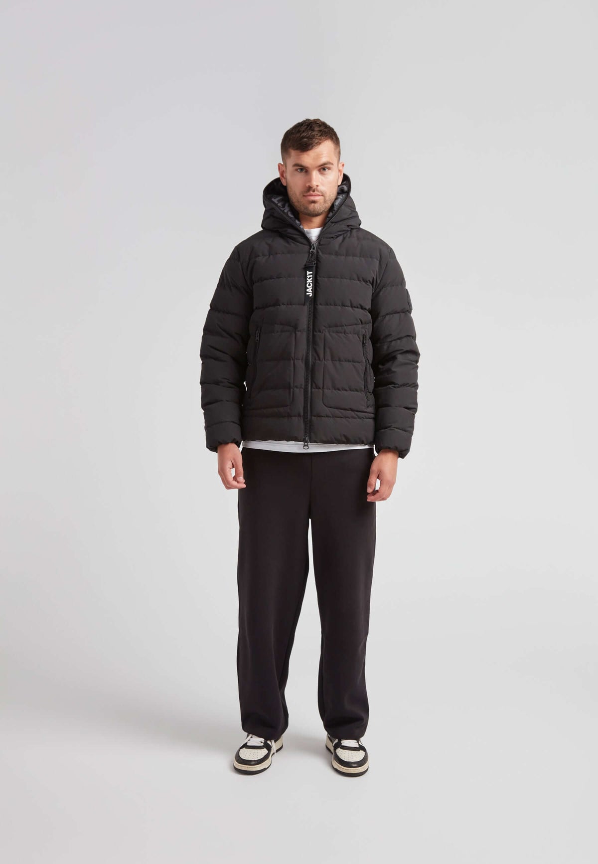 R4D Tramline Puffer Racer Jacket Matt Black worn by a man, showcasing modern winter fashion.