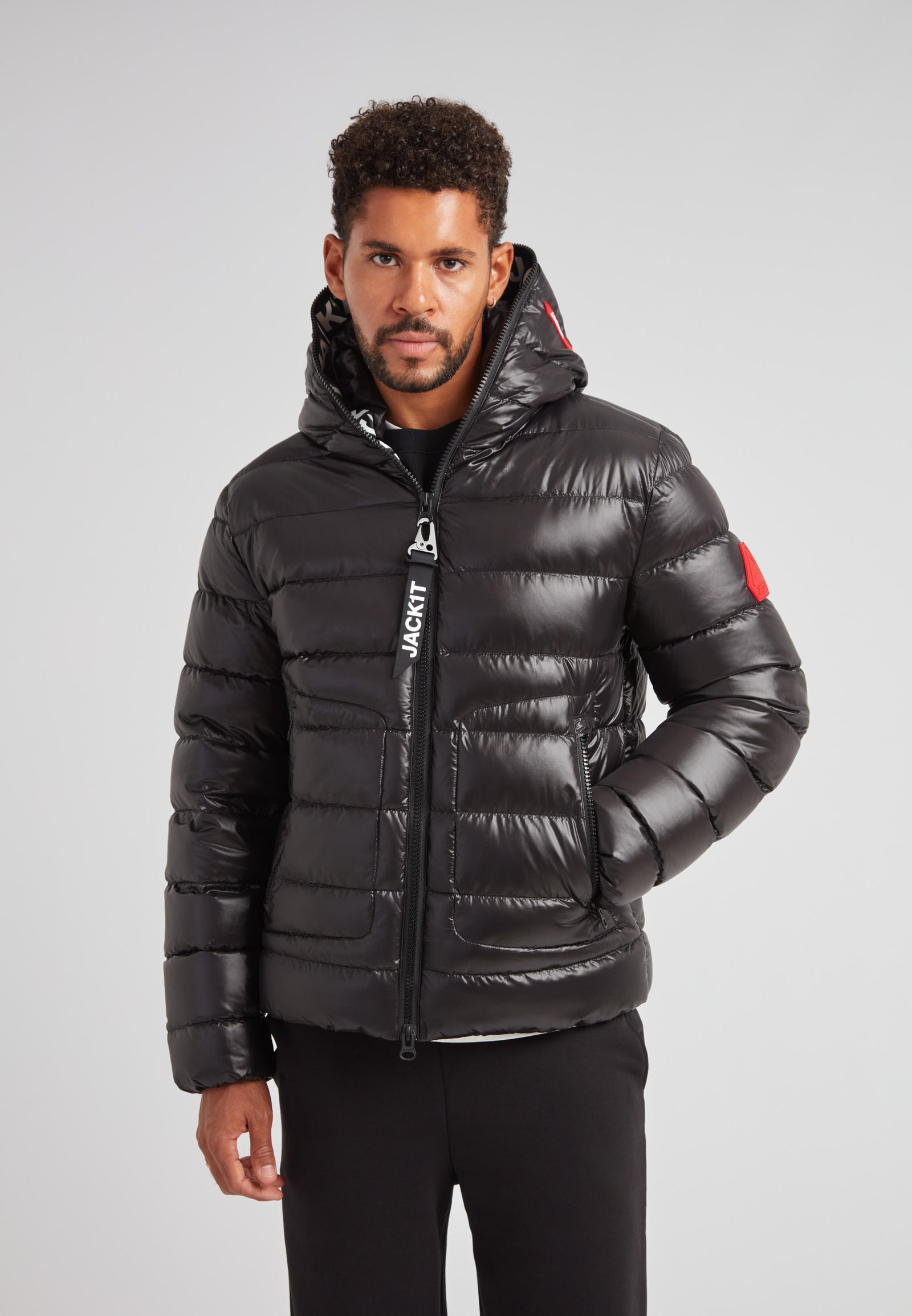R4D Tramline Puffer Racer Jacket Lux Black on model in sleek black with hood, showcasing modern technical outerwear design.