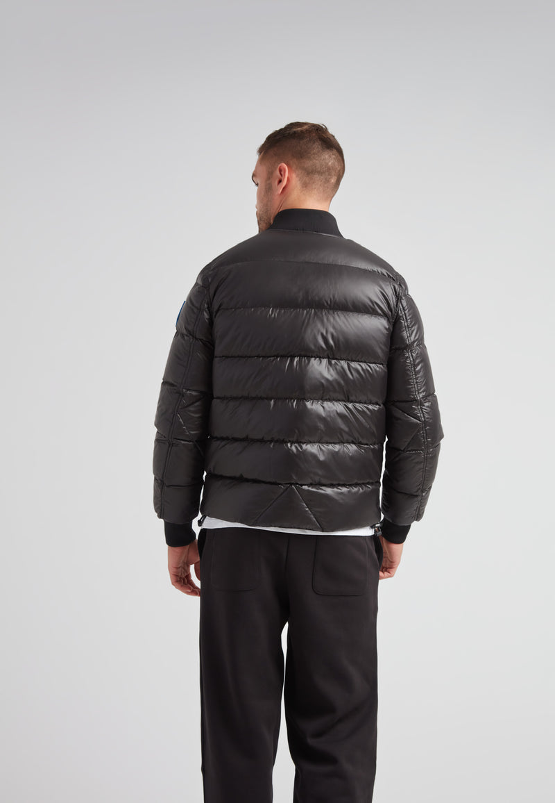 Back view of a man wearing the Vortex Black Bomber Jacket, showcasing its sleek design and comfortable fit.