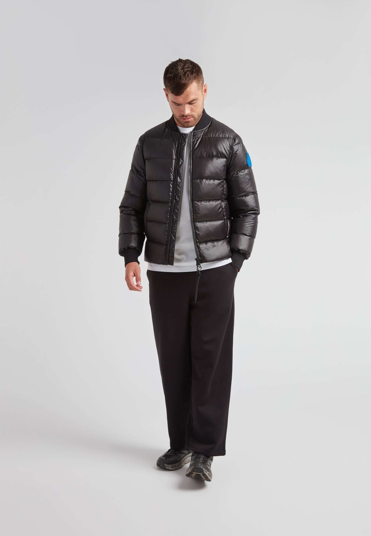 Vortex Black Bomber Jacket worn by a man, showcasing its sleek design and comfortable fit.
