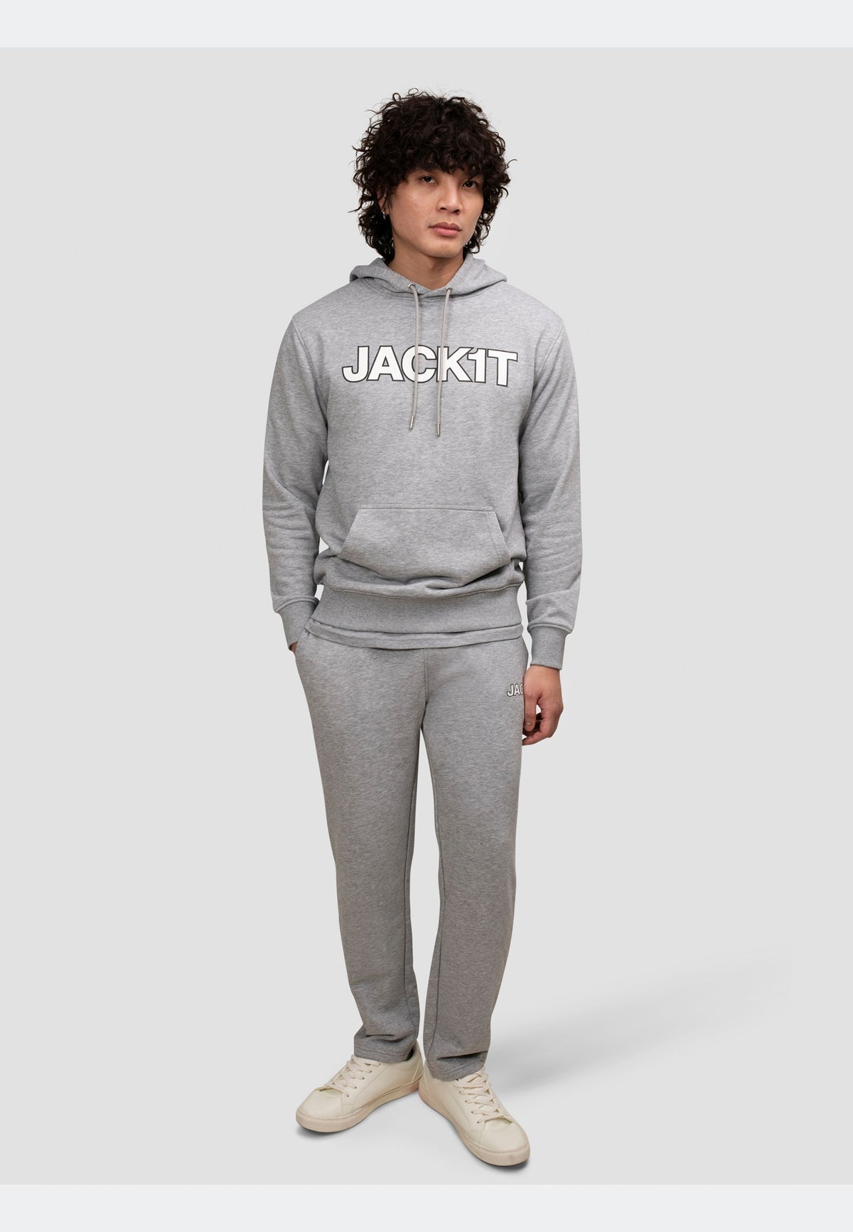 Man wearing a grey hoodie and matching joggers, showcasing a relaxed fit and premium casual style.