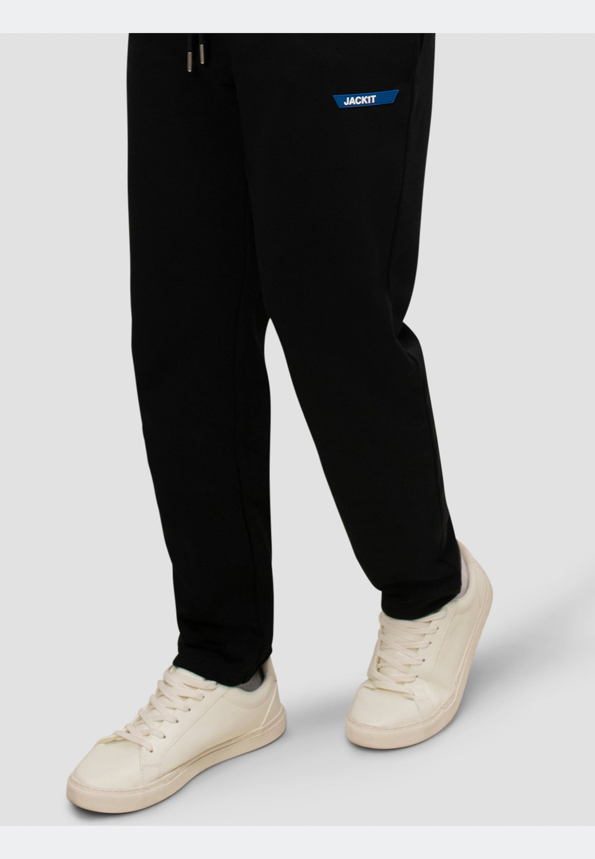 Casual outfit featuring black joggers paired with white sneakers, highlighting comfort and style.