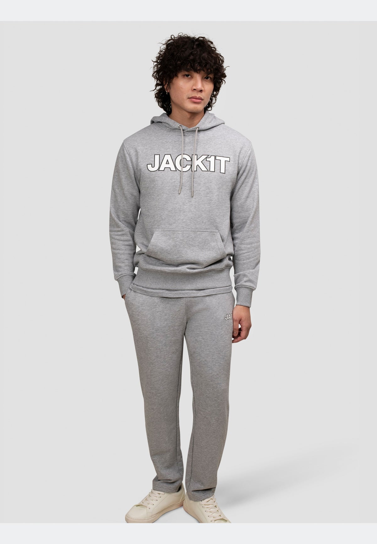 Man wearing grey joggers with a matching hoodie, showcasing a relaxed and stylish look.