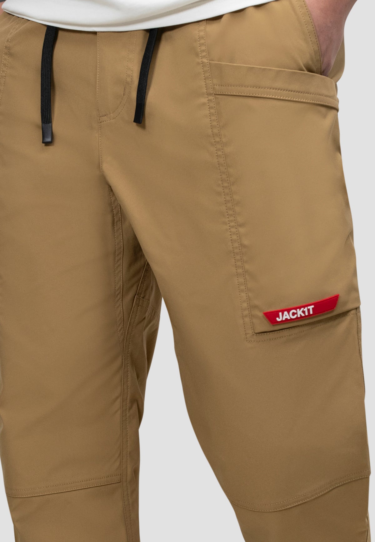 Men's sand cargo trousers with elastic waist and logo detail, perfect for casual wear and travel.