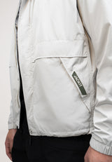 Mens lightweight stone windbreaker featuring a roll-out hood and elasticated cuff, showcased in a side view.