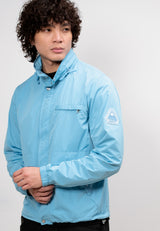 Model wearing Atlas Lightweight Windbreaker in sky blue, showcasing a men's blue windbreaker designed for spring and summer.