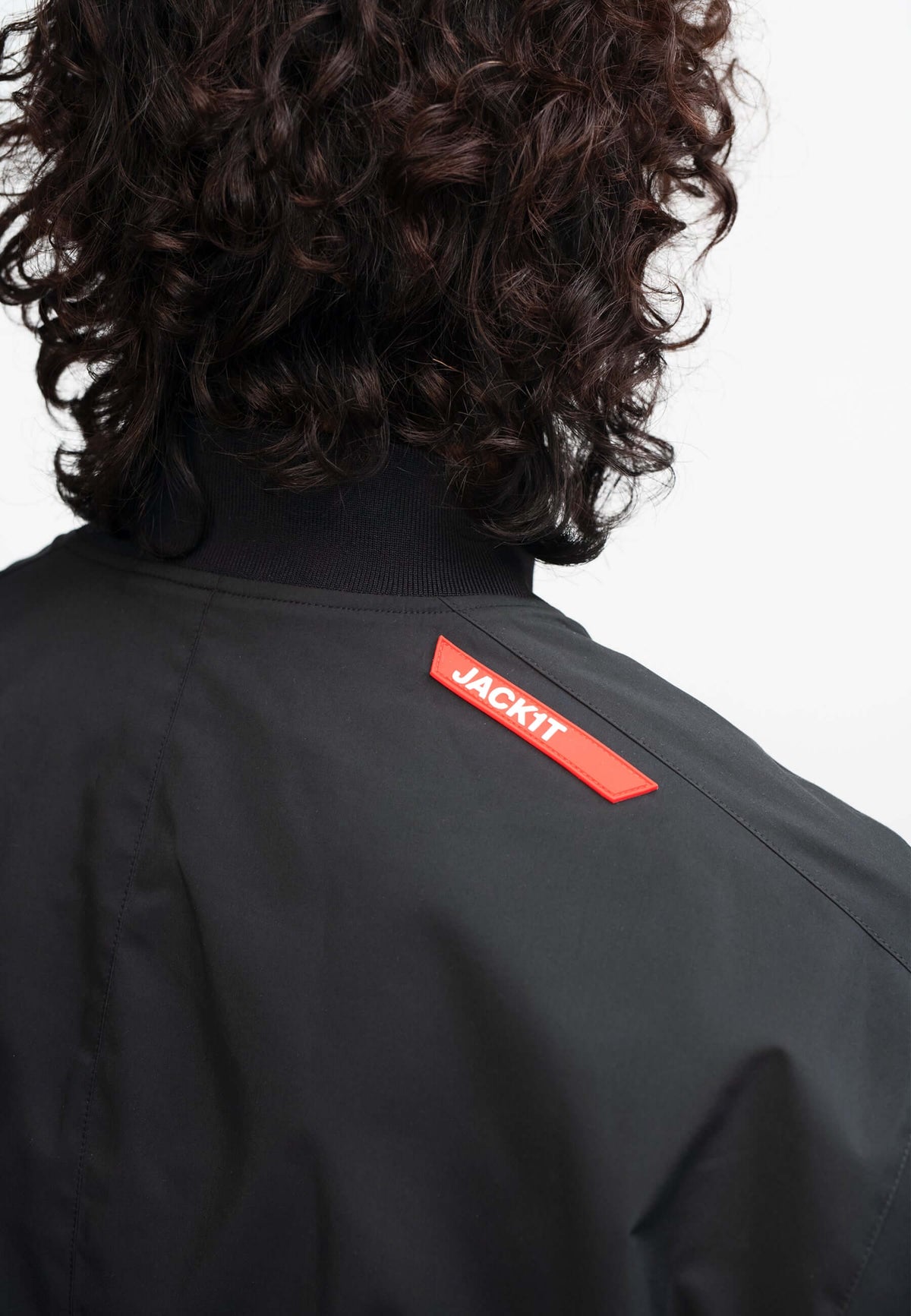 Mens black bomber jacket from Oberon Tech featuring a distinctive logo on the back, showcasing stylish design.