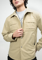 Mens Sand Shirt Jacket worn by a model, showcasing lightweight water-resistant fabric and adjustable cuffs.