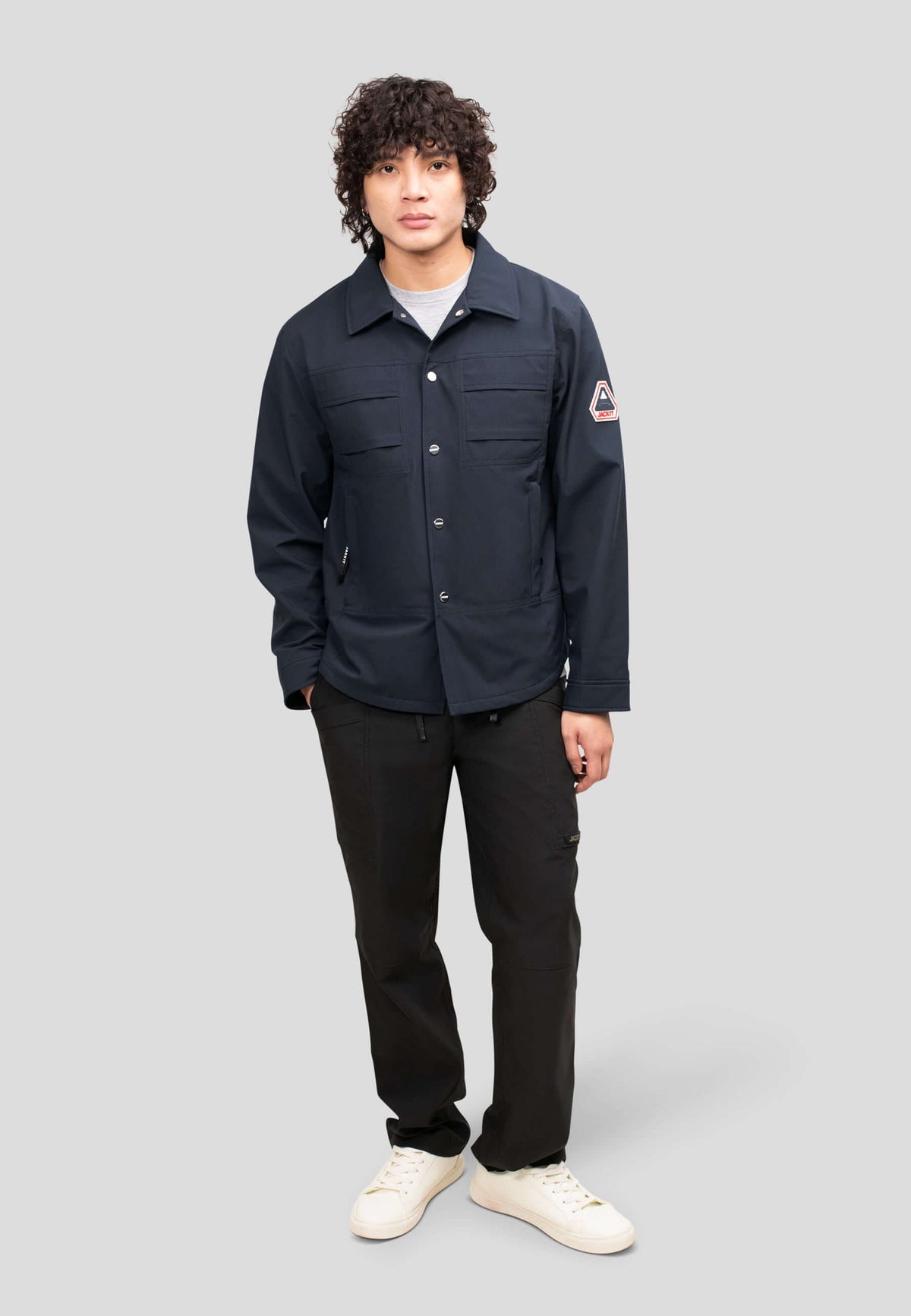Model wearing Mens Navy Shirt Jacket standing against a gray background showcasing its lightweight and stylish design.