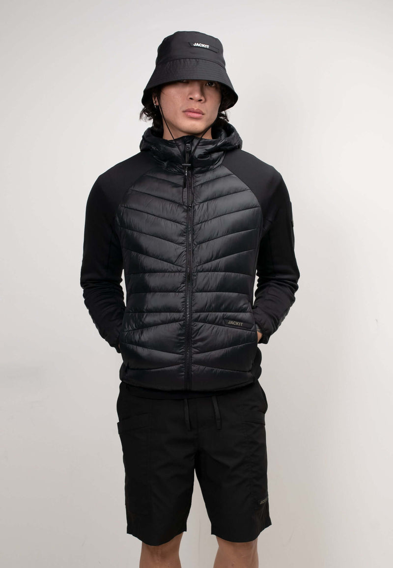 Men's black hooded jacket styled with shorts and a bucket hat, showcasing a lightweight design and THERMOLITE® insulation.